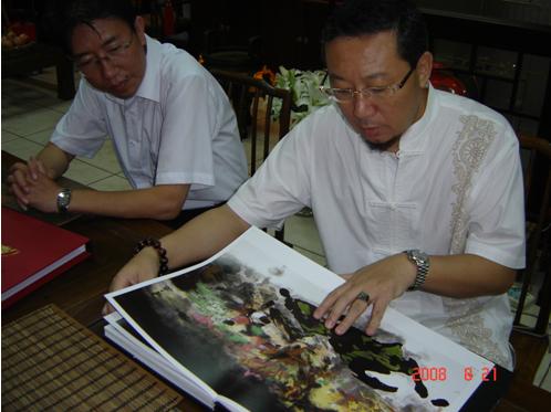 师父翻阅的正是“大红袍”：人民美术出版社编辑的《中国近现代名家画集》 。去